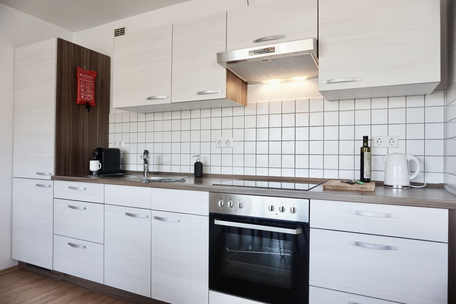 Küchenzeile mit Backofen, Kochfeld und Wasserkocher
