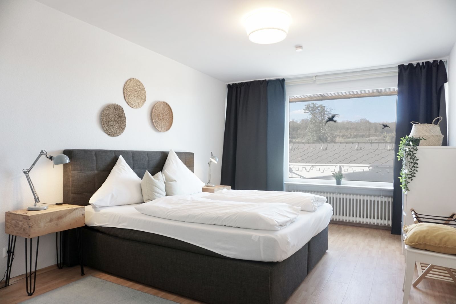 Schlafzimmer mit Boxspringbett und großem Fenster